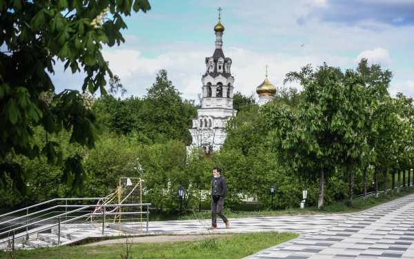 Прохожий у храма Ильи Пророка в Черкизове в Москве во время режима самоизоляции жителей