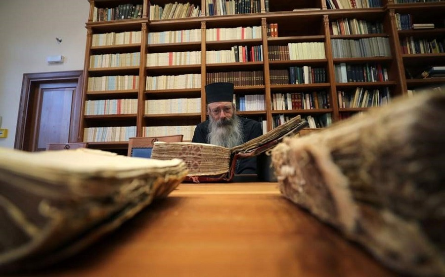 Библиотекарь отец Юстин изучает манускрипт в библиотеке монастыря Святой Екатерины