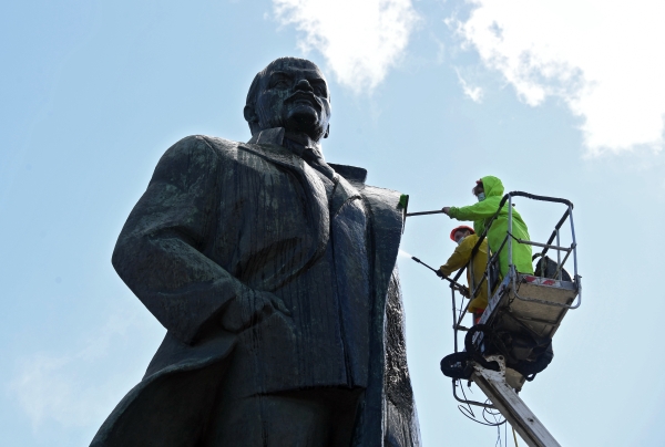 Работники коммунальных служб моют памятник В. И. Ленину на Калужской площади в Москве