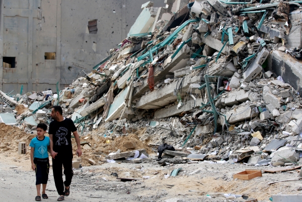 Жители Газы на улице, поврежденной в результате бомбардировки в секторе Газа