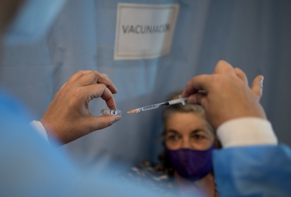 Медицинский сотрудник наполняет шприц вакциной от COVID-19 для вакцинации жителей Каракаса