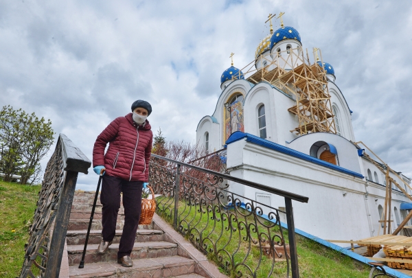 Верующая спускается по лестнице возле Храма Воскресения Христова в Минске