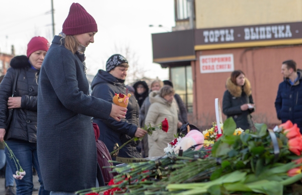 Жители возлагают цветы и мягкие игрушки к мемориалу в память о жертвах пожара в торгово-развлекательном центре 