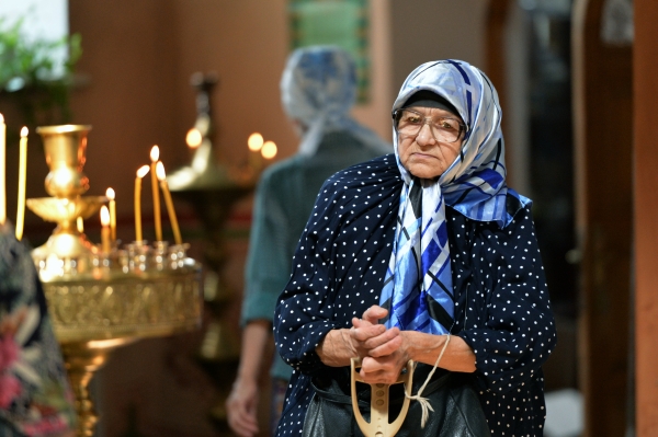 Верующая во время богослужения в честь праздника Преображения Господня в храме Михаила Архангела в Грозном