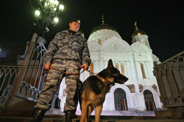 Кинолог с собакой у Храма Христа Спасителя проверяет посетителей перед началом праздничной пасхальной службы