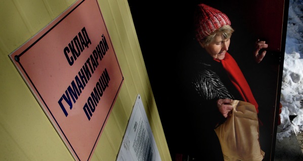 Жительница Владивостока выходит со склада гуманитарной помощи с пакетом продуктов