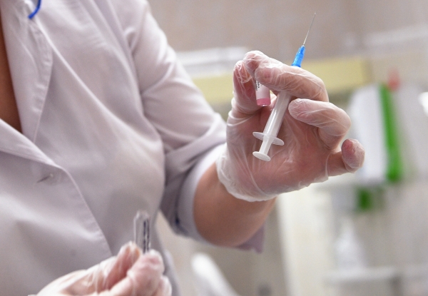 Медицинская сестра готовит шприц для прививки от кори в детской поликлинике в Москве