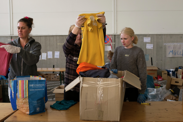 Волонтеры сортируют и упаковывают вещи, собранные для беженцев с Ближнего Востока